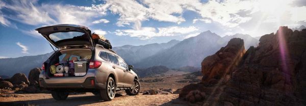 2019 Subaru Outback with open hatch parked in front of desert mountain range